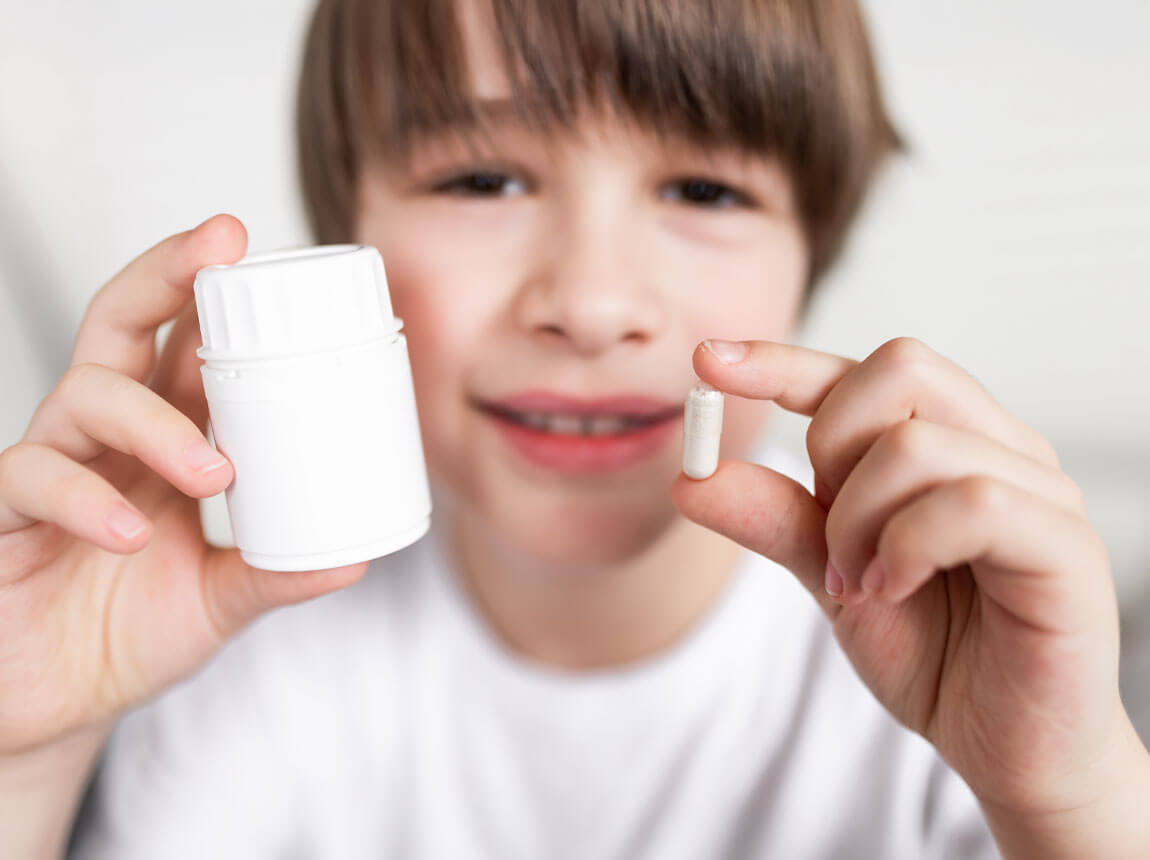 boy with vitamin capsule