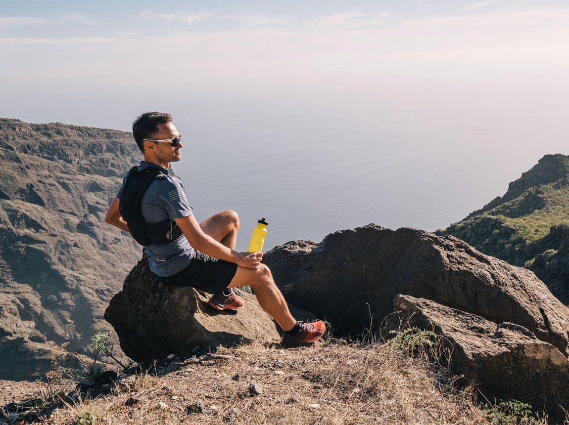 hot day - man with isotonic drink in the mountains